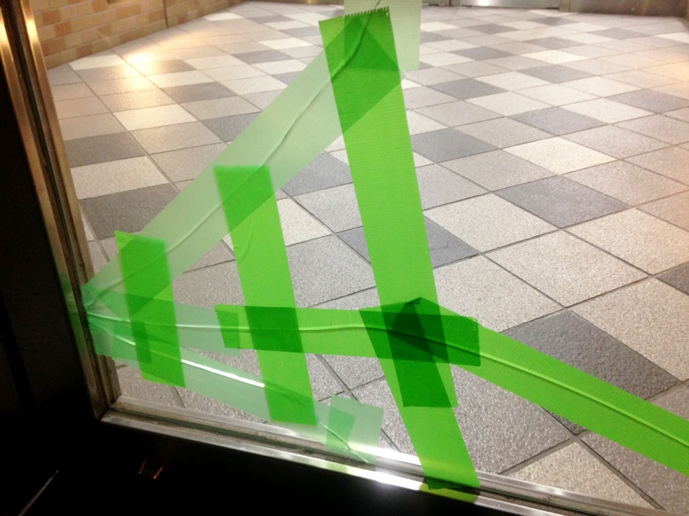 養生テープで補修しているガラス