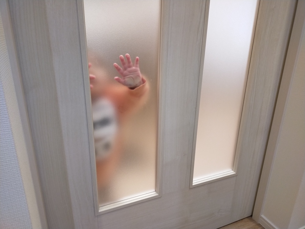 すりガラスに近づいている子供
